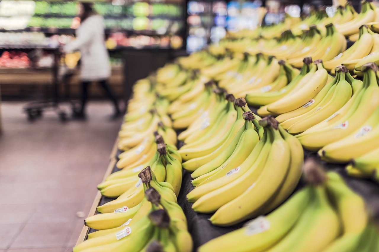 Rayon des fruits d'un supermarché proposant une large sélection de bananes mûres.