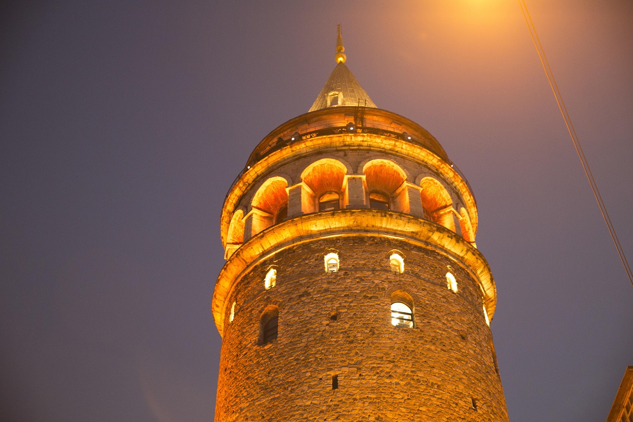 La tour de Galata illuminée se dresse fièrement dans le ciel nocturne de Beyoğlu.