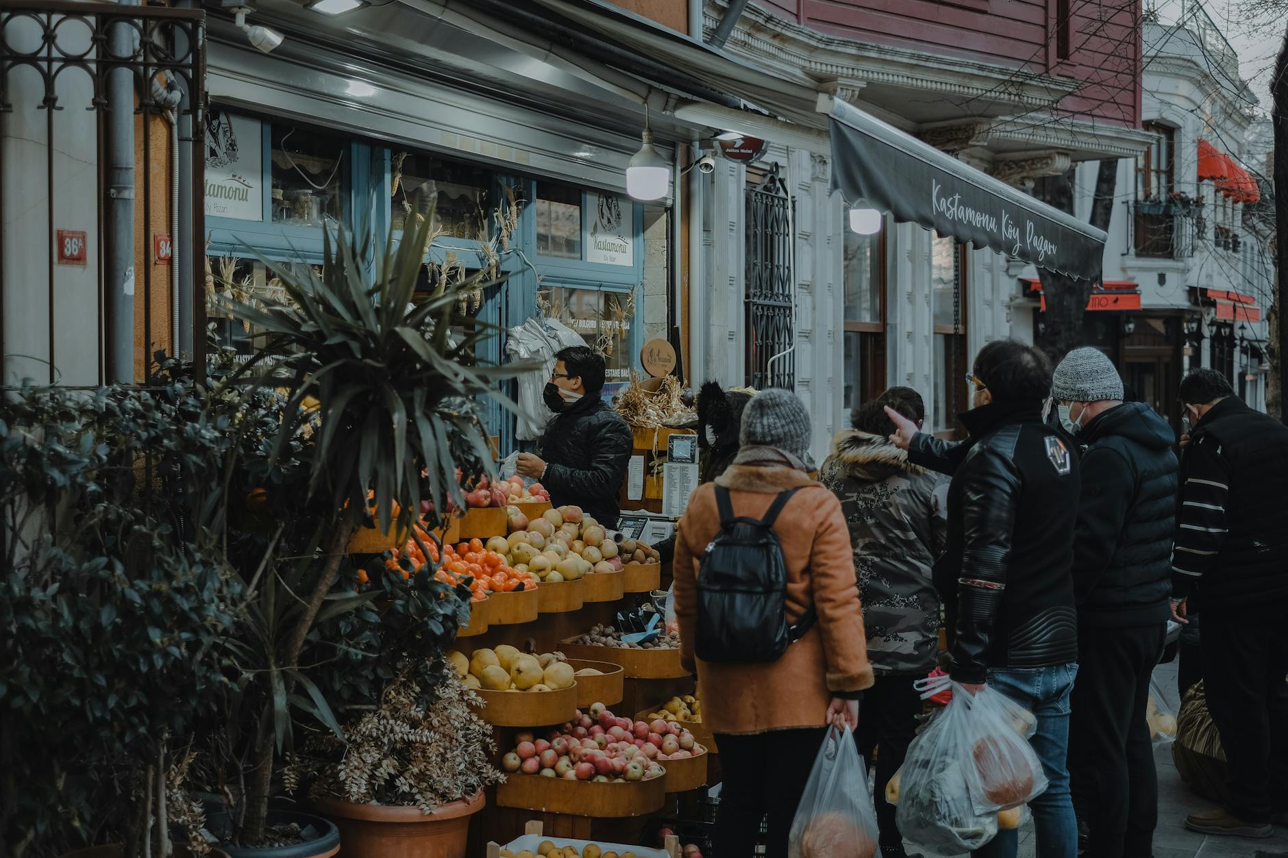 Des clients achètent des fruits frais devant une épicerie locale à Istanbul.