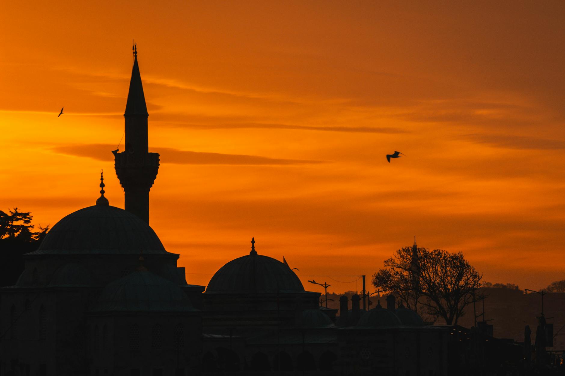 Silhouette d'une mosquée d'Üsküdar se découpant sur un ciel de coucher de soleil flamboyant.