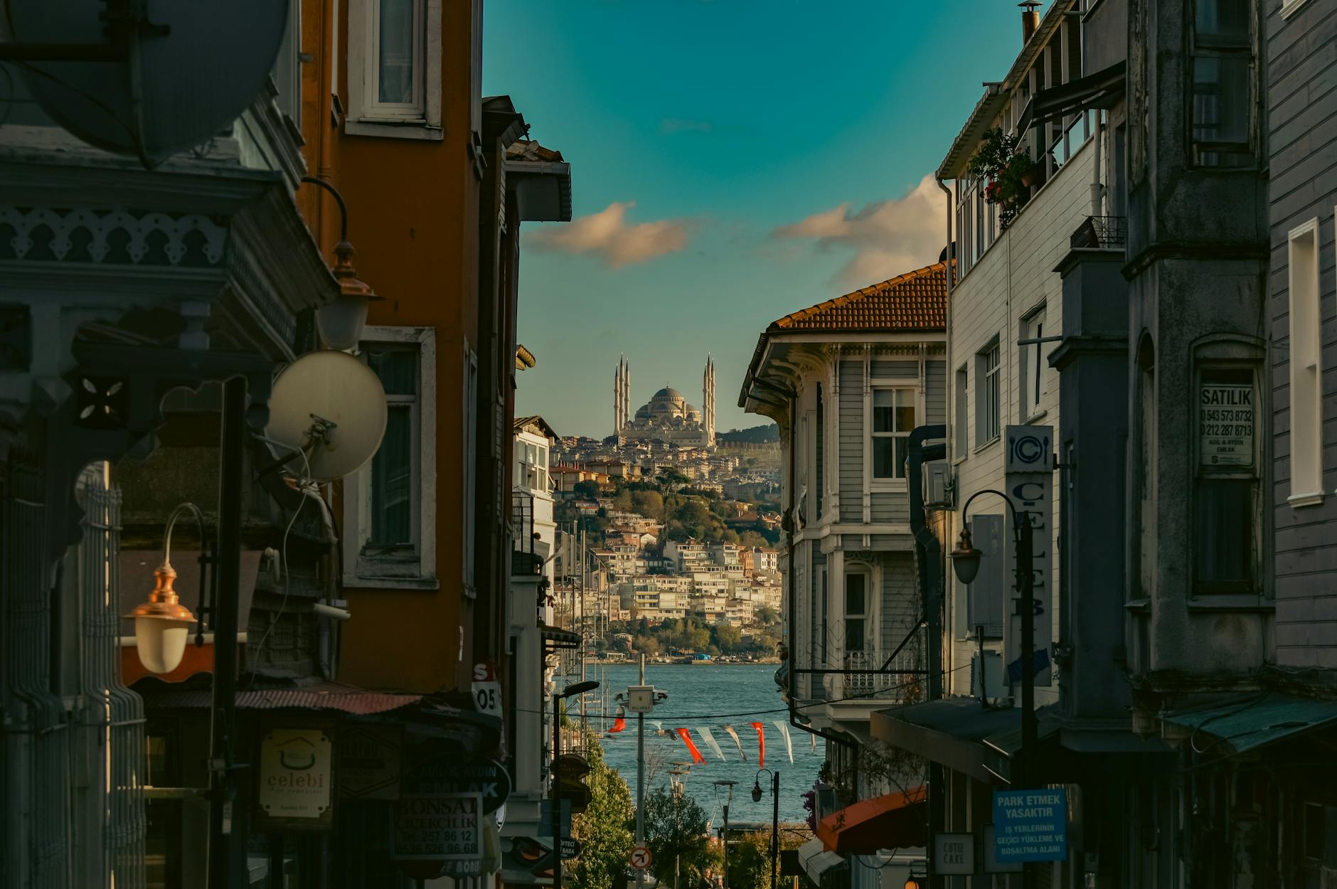 Rue en pente bordée de demeures en bois offrant une vue sur le Bosphore.